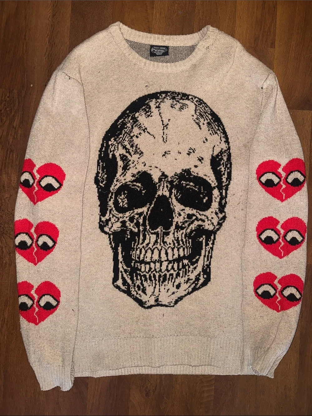 “RGSTR” Crewneck Beige Knit Sweater with Black Skull and Red Heart Sleeve Motifs